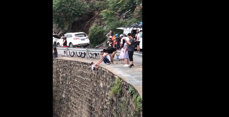 家長(zhǎng)把孩子掛峭壁上拍照 孩子表示年輕父母太難帶了